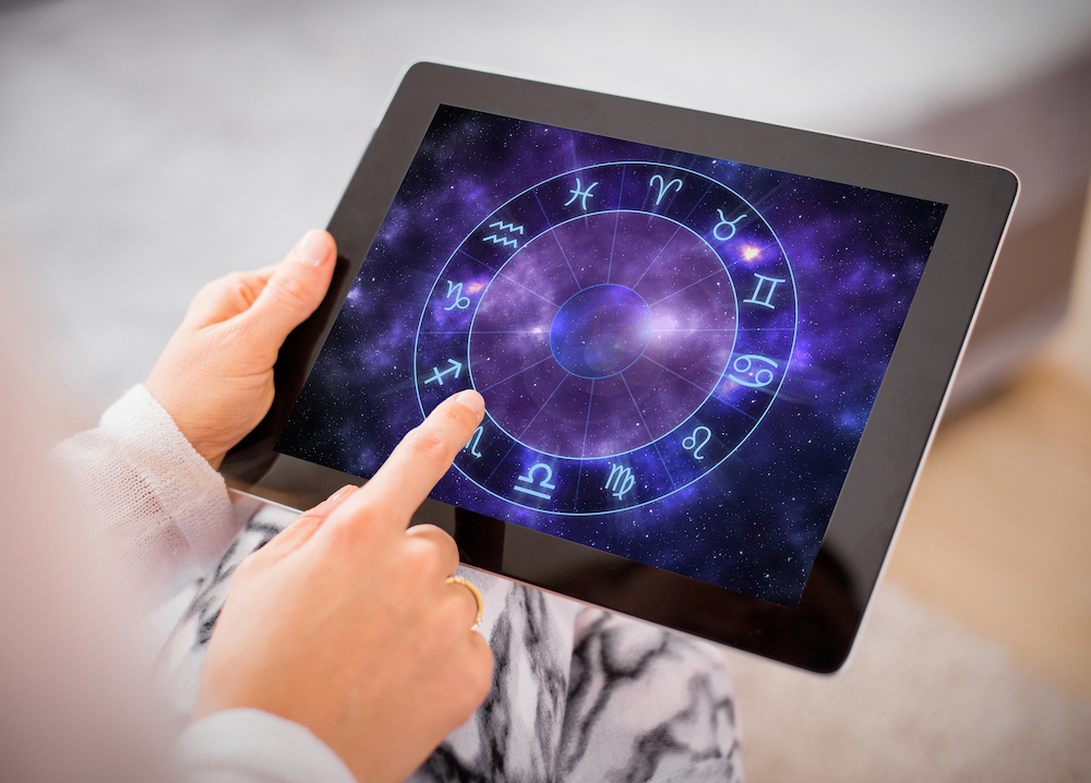 Woman reading horoscopes on tablet